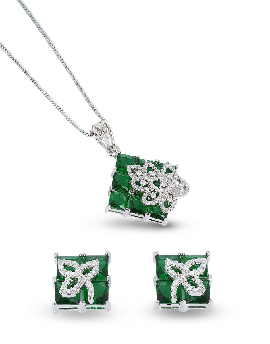 Jewelry set with emerald green gemstones and silver accents on a white background