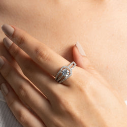 Silver ring with a diamond on a hand against a neutral background