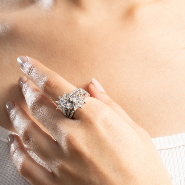 Close-up of a hand wearing a diamond ring on a blurred background